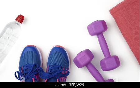 Ein Paar blaue Sneaker, Kunststoff-Hanteln für Sport auf weißem Hintergrund, Sport-Hintergrund, Draufsicht, Copy-Space Stockfoto