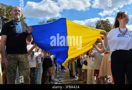 Lwiw, Ukraine. 23. Aug., 2026. Ukrainer marschieren mit der Nationalflagge während der Feier. Ukrainer halten eine 35 Meter lange Nationalflagge während einer öffentlichen Veranstaltung zum Gedenken an den Nationalflaggentag in Lwiw, Westukraine. Der Nationalflaggentag wird jährlich in der Ukraine am 23. August gefeiert, um eines der wichtigsten Staatssymbole des Landes zu ehren. (Foto von Mykola Tys/SOPA Images/Sipa USA) Credit: Sipa USA/Alamy Live News Stockfoto