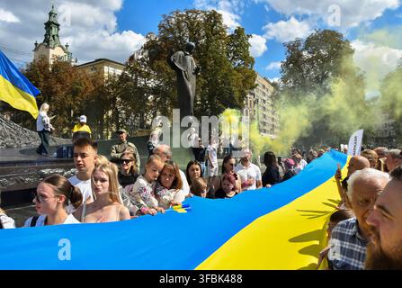 Lwiw, Ukraine. 23. Aug., 2026. Ukrainer marschieren mit der Nationalflagge während der Feier. Ukrainer halten eine 35 Meter lange Nationalflagge während einer öffentlichen Veranstaltung zum Gedenken an den Nationalflaggentag in Lwiw, Westukraine. Der Nationalflaggentag wird jährlich in der Ukraine am 23. August gefeiert, um eines der wichtigsten Staatssymbole des Landes zu ehren. (Foto von Mykola Tys/SOPA Images/Sipa USA) Credit: Sipa USA/Alamy Live News Stockfoto