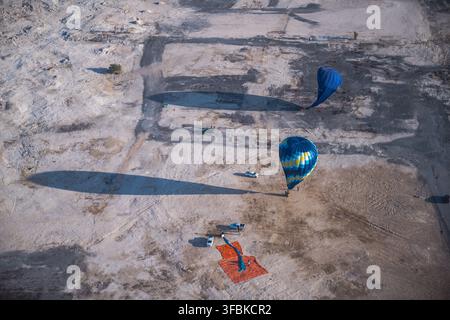 Luftaufnahme von Heißluftballons, die sich in der Wüste vorbereiten Stockfoto