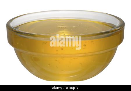 Goldener Honig in einer Glasschale auf isoliertem Hintergrund, Nahaufnahme Stockfoto