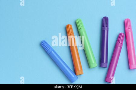 Mehrfarbige Filzstifte auf blauem Hintergrund, Draufsicht Stockfoto