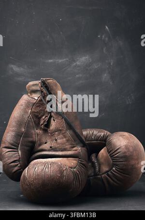 Braune Leder Vintage Boxhandschuhe auf schwarzem Hintergrund, Sportausrüstung Stockfoto