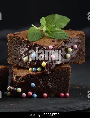 Gebackene Brownie-Schokoladenstückchen auf einem schwarzen Tisch Stockfoto
