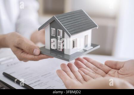 Immobilienmakler erklären das Dokument für Kunden, die in Verbindung zu setzen, um ein Haus zu kaufen, zu kaufen oder Immobilien Konzept verkaufen Stockfoto