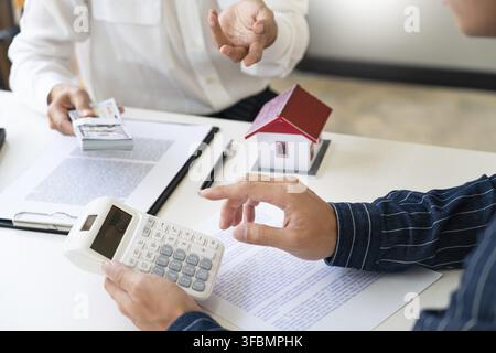 Immobilienmakler erklären das Dokument für Kunden, die in Verbindung zu setzen, um ein Haus zu kaufen, zu kaufen oder Immobilien Konzept verkaufen Stockfoto