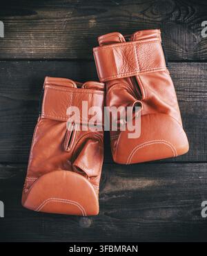 Paar rote Leder Handschuhe für den Boxsport auf braunem Holz- Hintergrund Stockfoto