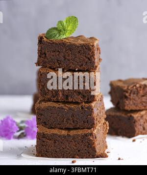 Stapel der quadratische Scheiben gebackene Brownie pie auf eine weiße Fläche, in der Nähe Stockfoto