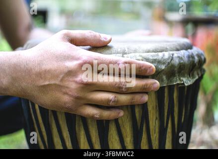 Schlagzeugerhände spielen die ethnische Djembe-Trommel im Freien Stockfoto