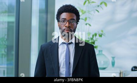 Portrait eines selbstbewussten, ernsten afroamerikanischen Geschäftsmannes, der in ein Büro einer Marketingagentur schaut, ethnischer Geschäftsmann, männlicher Manager Stockfoto
