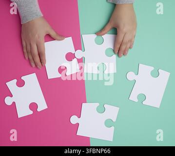 Leere Papier weiß Stück des Puzzles in weibliche Hände, Puzzle, bunten Hintergrund, Ansicht von oben Stockfoto