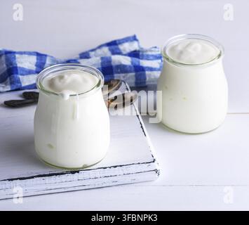 Zwei Gläser mit Milch, Joghurt, hausgemachte auf weißem Holz- Hintergrund Stockfoto