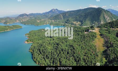 Luftbilddrohnenaufnahme der Bucht des Plastira-Sees, umgeben von dichtem grünem Wald und majestätischen Berggipfeln der Region Thessalien Stockfoto