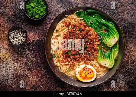 Eine Schüssel Nudeln mit Hackfleisch, Ei und Bok Choy. Miso-Ramen-Suppe, Ansicht von oben. Stockfoto