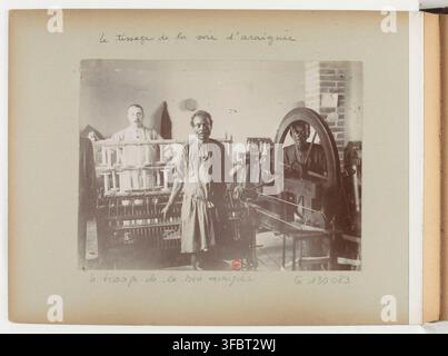 Arbeiter betreiben Seidenwebmaschinen in Madagaskar, einer französischen Kolonie in Afrika, in einer Fotografie aus dem frühen 20. Jahrhundert, Teil einer Sammlung, die die französische Kolonisation in Madagaskar dokumentiert. Stockfoto