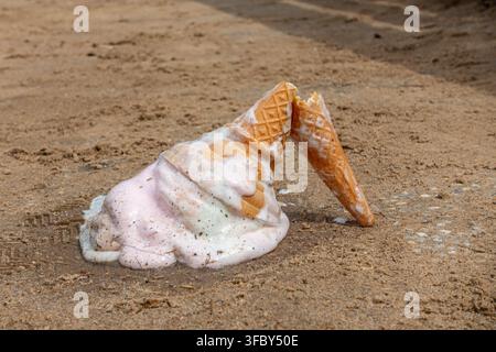 Ein Eisbecher ist heruntergefallen und auf den Boden gefallen, wo es zum Schmelzen liegen gelassen wurde Stockfoto