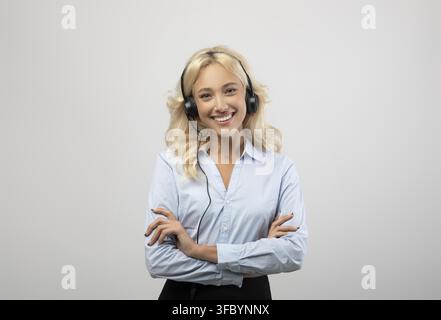 Lächelnde junge schwarze Frau mit Headset im Büro, Kundenservice-Konzept Stockfoto