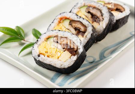 Japanische Futomaki Dicke Sushi-Rollen auf Keramteller isoliert auf weißem Hintergrund Stockfoto