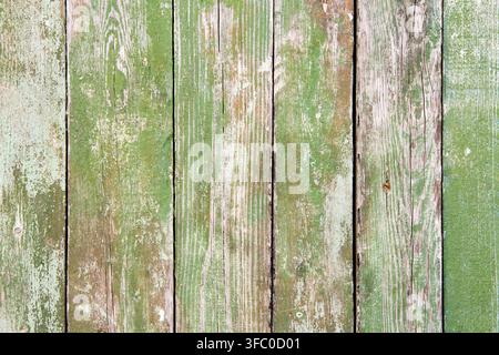 Holzbretter, bedeckt mit alter abblätternder grüner Farbe. Textur von vertikalen Holzbrettern. Stockfoto