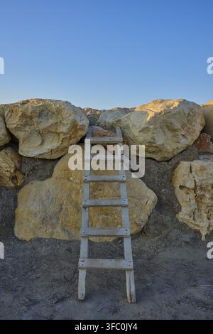 Holzleiter lehnt an einer Steinmauer unter einem klaren Himmel, Marina, Evrenseki, Manavgat, Antalya, Türkische Riviera, Mittelmeer, Türkei Stockfoto