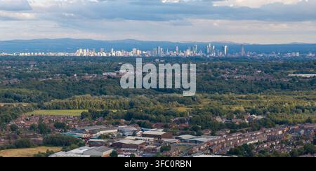 Luftbild mit Teleobjektiv von Wohnsuburban und der fernen Skyline von Manchester aus Bury Stockfoto
