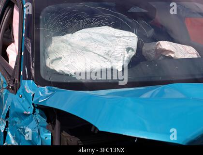 Zersprungene Windschutzscheibe mit einem Airbag im Inneren des Autos nach einem Straßenunfall. Vorderansicht, Nahaufnahme. Stockfoto