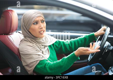 Wütend muslimische Frau in Hijab fahren ihr Auto und streiten Stockfoto