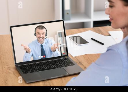 Junge Frau mit Gespräch mit Service-Center-Vertreter online Stockfoto