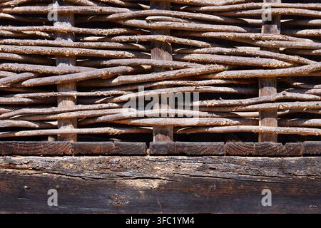 Rustikaler Weidenzaun als Texturrückgrund aus natürlichen Holzreisern Stockfoto