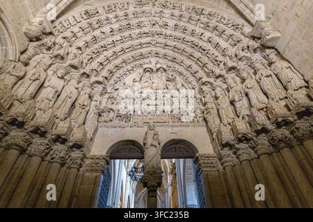 Ein kunstvolles gotisches Steinportal zeigt aufwendige bildhauerische Reliefs und religiöse Figuren in einer historischen Kathedrale in Spanien. Stockfoto