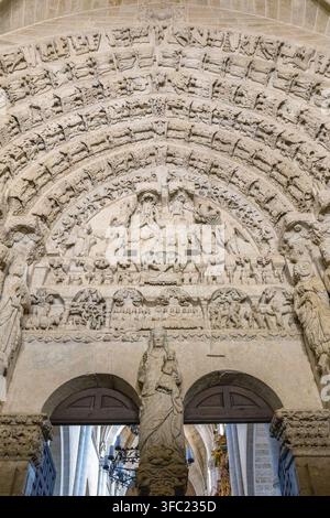 Ein kunstvolles gotisches Steinportal zeigt aufwendige bildhauerische Reliefs und religiöse Figuren in einer historischen Kathedrale in Spanien. Stockfoto