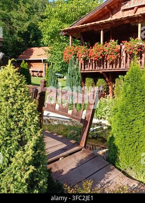 Charmante Holzbrücke und rustikale Gartenhütte im Sommer Stockfoto
