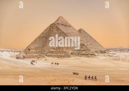 Ägypten, Kairo, Gizeh, Memphis und seine Nekropole, die Gebiete um die Pyramiden von Gizeh und Dahschur, die als UNESCO-Weltkulturerbe gelistet sind, Kamele vor den Pyramiden Stockfoto