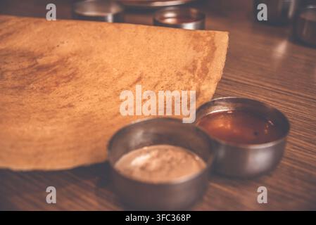 Selektive Fokussierung von Masala Dosa indischen herzhaften Crêpes mit Kartoffelfüllung und Chutneys, d.h. Pasten Stockfoto