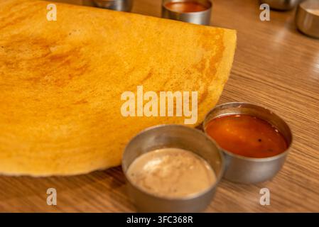 Selektive Fokussierung von Masala Dosa indischen herzhaften Crêpes mit Kartoffelfüllung und Chutneys, d.h. Pasten Stockfoto