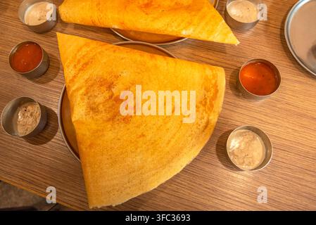 Selektive Fokussierung von Masala Dosa indischen herzhaften Crêpes mit Kartoffelfüllung und Chutneys, d.h. Pasten Stockfoto