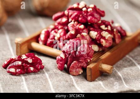 Roter Walnusskern, auf einem hölzernen Schaufel auf gestreiftem Leinentuch gestapelt. Stockfoto