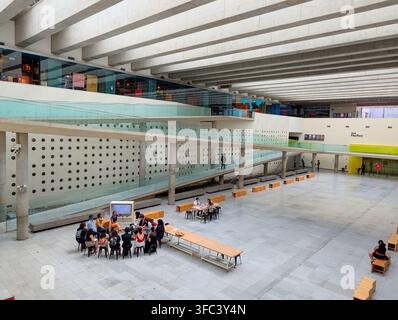 SANTIAGO, CHILE - 03. DEZEMBER 2025: Menschen versammeln sich in der geräumigen unterirdischen Halle des Centro Cultural La Moneda in Santiago, Chile. Stockfoto