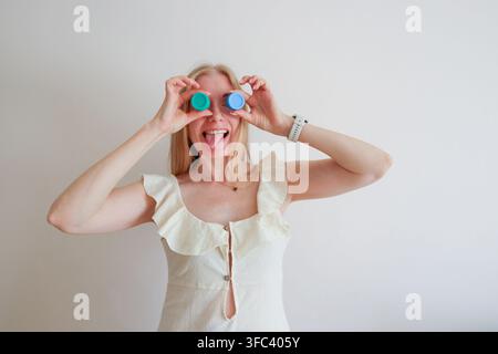 Glückliche Frau hat Spaß mit bunten Farbbehältern, kreatives Hobby und verspieltes Kunstkonzept mit Kopierraum. Stockfoto