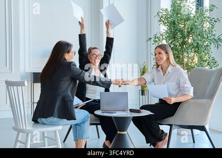 Aufgeregtes Geschäftsteam feiert Sieg und Abschluss des Geschäfts während eines Meetings im Büro Stockfoto