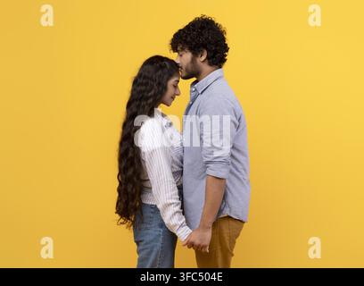 Paar umarmt sich mit verbundenen Händen, junger hispanischer Mann und Frau, romantischer Moment Stockfoto