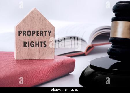 Richterschläger mit Text über Eigentumsrechte auf einem Holzhaus auf weißem Hintergrund. Konzept des Eigentums. Stockfoto