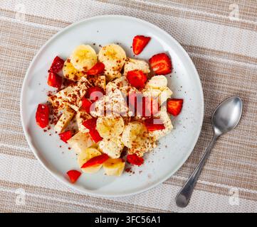 Eis mit Bananen und Erdbeeren auf dem Teller serviert Stockfoto