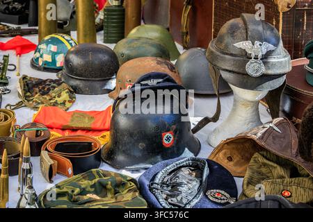 Sanremo, Italien - 11. Oktober 2025: Vintage-WWII-deutsche Militaria, Stahlhelme, Leder-Munitionsgürtel und Tarnmützen auf dem Flohmarkt Stockfoto