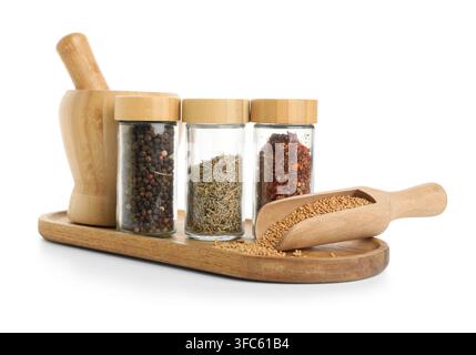 Kochen und kulinarische Gewürze, verschiedene getrocknete Kräuter und Gewürzmischungen in Gläsern mit einem Mörser und Stößel auf einem Holztablett Stockfoto