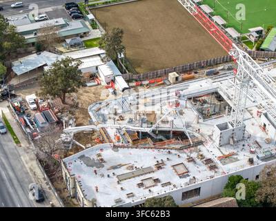 Melbourne, Australien - 24. August 2026: Luftaufnahme einer Baustelle in Croydon mit einem großen Kran, Betonfundamenten und Arbeitern vor Ort. Stockfoto