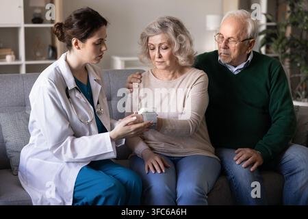 Arzt misst der Seniorin den Blutdruck während eines Hausbesuchs Stockfoto
