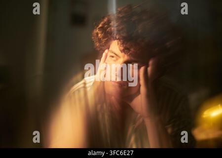 Nachdenklicher Mann, der den Kopf in den Händen hält und mentalen Stress ausdrückt Stockfoto