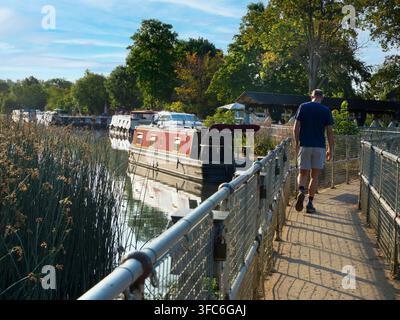 Blick flussaufwärts von der Abingdon-Wehranlage auf die Themse am frühen Morgen. Abingdon-on-Thames behauptet, die älteste Stadt Englands zu sein. Und die Themse fließt durch ihr Herz. In dieser idyllischen Szene sehen wir einen ganz schönen Blick flussaufwärts von den Abingdon-Schleusen, gerade als die Sonne an einem schönen Sommermorgen aufgeht. So ruhig... Es gibt nur wenige Aufnahmen, für die es sich lohnt, um 5:30 Uhr morgens aufzustehen, um sie einzufangen – aber das hier ist mit Sicherheit eine davon! Stockfoto