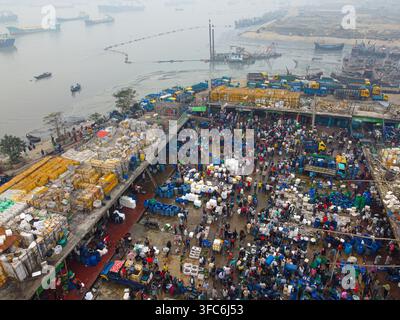 Luftaufnahme eines geschäftigen Fischmarkts mit zahlreichen Menschen, farbenfrohen Kisten und Booten, die entlang des Flusses in Chattogram, Chittagong-Division, Bangladesch, angelegt sind Stockfoto